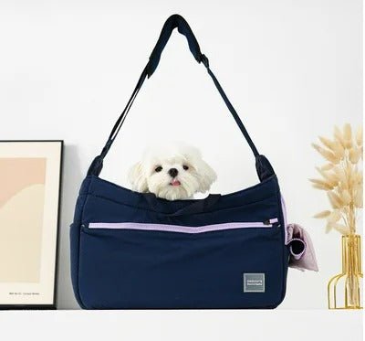 Un petit chien blanc sort d'un élégant  sac de transport polyvalent pour chien | coupe - vente  , bleu marine avec une fermeture éclair violette, placé sur une table moderne avec un décor minimaliste.
